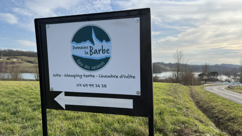 Cartel en Domaine La Barbe en Occitanie, Francia, indicando alojamiento en parque vacacional.