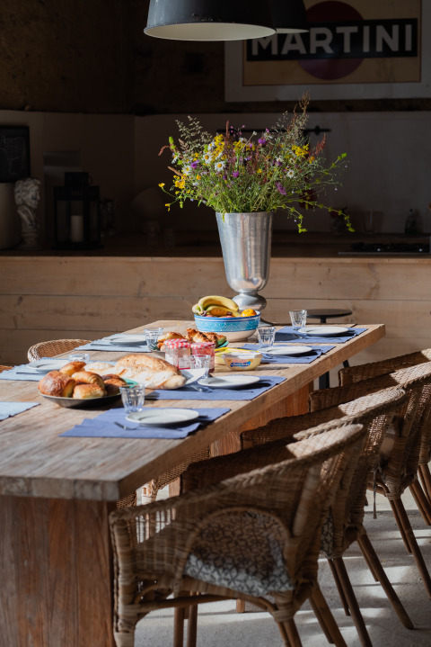 Rustieke houten tafel met koffiekoeken en bloemen op Domaine La Barbe, een vakantiepark in Occitanië, Frankrijk.