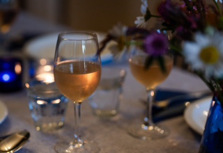 Table de dîner au Domaine La Barbe, Occitanie, France, avec verres de vin, bougies et fleurs.