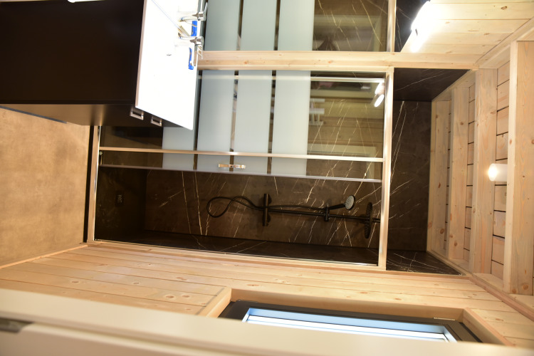 Baño moderno con paneles de madera y ducha de vidrio en Ecolodge en Hameau de l'Ourthe, Bélgica.