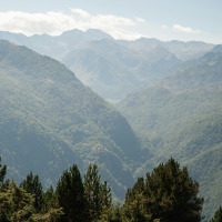 View of lush green mountains and forested hills near Lalanne-Arqué in Occitanie, France.