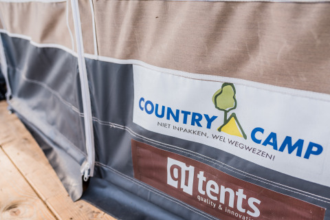 Close-up of a tent at Auf Kengert Lodge de Luxe in Luxembourg, showing Country Camp and qi tents logos.