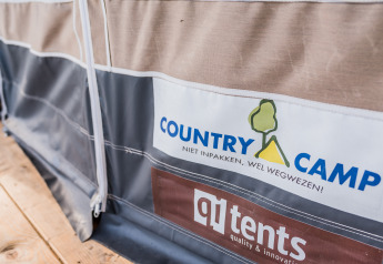 Primer plano de una tienda en Auf Kengert Lodge de Luxe en Luxemburgo con logos de Country Camp y qi tents.