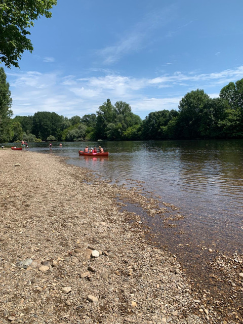 Persone in canoa e sulla riva del fiume al Camping Le Clou, parco vacanze in Nouvelle-Aquitaine, Francia.