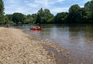 Persone in canoa e sulla riva del fiume al Camping Le Clou, parco vacanze in Nouvelle-Aquitaine, Francia.