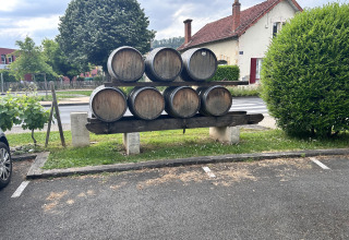 Houten vaten gestapeld buiten aan een huis bij Camping Le Clou in Nouvelle-Aquitaine, Frankrijk, nabij parking.