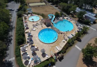 Vista aerea delle piscine e dello scivolo acquatico a Camping Le Clou, parco vacanze in Nouvelle-Aquitaine, Francia.