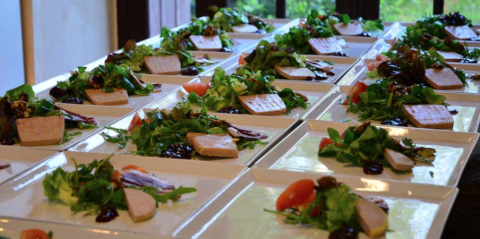 Rows of fresh starter plates with salad and pâté on square dishes prepared for serving at Camping Le Clou.