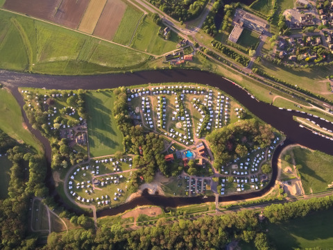 Luchtfoto van Camping de Koeksebelt in Overijssel met kampeerplaatsen, rivier en groene omgeving.