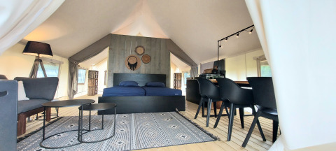 Interior view of a luxury safari tent at Beloofde Land in the Netherlands, featuring modern decor.
