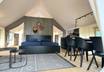 Vista interior de una tienda de safari de lujo en Beloofde Land, Países Bajos, con decoración moderna.
