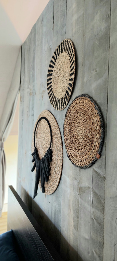 Woven wall decorations on rustic wood inside a Safaritent at Beloofde Land, Netherlands.