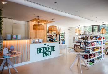 Recepción y tienda modernas en un alojamiento glamping, con estantes llenos y decoraciones de madera natural.
