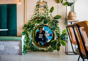 Un niño juega en un túnel verde junto a la carpa Jippi Tippi en Beloofde Land, Países Bajos.