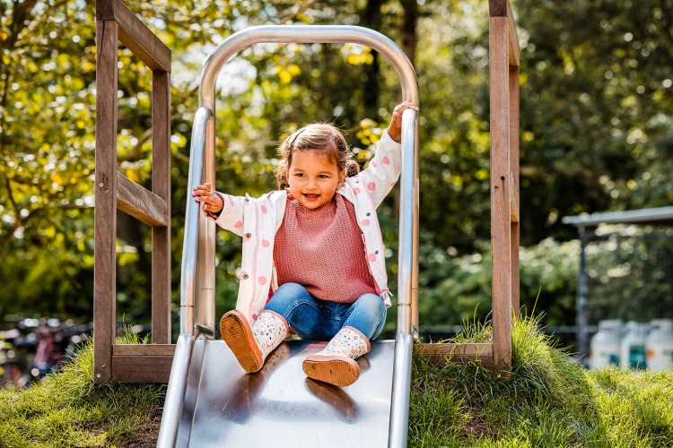 Un jeune enfant s’amuse sur un toboggan près de la tente tipi Jippi Tippi à Beloofde Land, Pays-Bas.