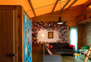 LEGO-themed safari tent interior with colorful decor and sofa at Lego huisje in Beloofde Land, Netherlands.