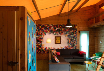 LEGO-inspirierter Wohnraum mit Sofaecke und bunter Deko im Lego-huisje auf Beloofde Land, Niederlande.