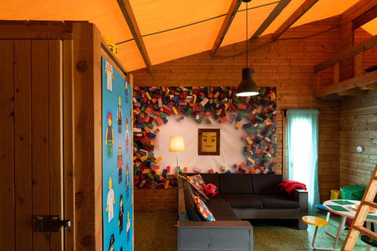 LEGO-inspirierter Wohnraum mit Sofaecke und bunter Deko im Lego-huisje auf Beloofde Land, Niederlande.