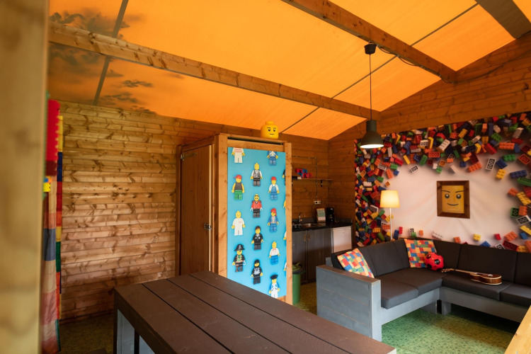 Binnenaanzicht van safaritent Lego huisje op Beloofde Land in Nederland met Lego-thema decoratie.