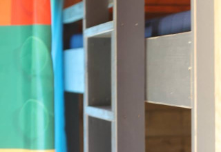 Photo of a bunk bed and colorful shower curtain in the Lego huisje safari tent at Beloofde Land, Netherlands.
