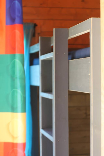 Photo of a bunk bed and colorful shower curtain in the Lego huisje safari tent at Beloofde Land, Netherlands.