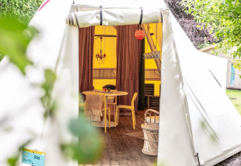 Entrada a la tienda tipi Jippi Tippi en Beloofde Land, Países Bajos, con interior decorativo y acogedor.