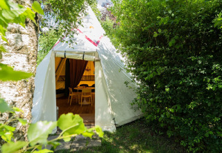Ingang van de Jippi Tippi tent op Beloofde Land in Nederland, omgeven door groene natuur.
