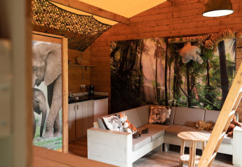 Interior de una tienda safari en Jungle huisje, Beloofde Land, Países Bajos, con cojines y peluches de animales.
