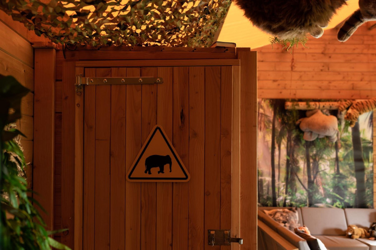 Interieur van een safaritent bij Jungle huisje, Beloofde Land, Nederland, met junglethema en hout.