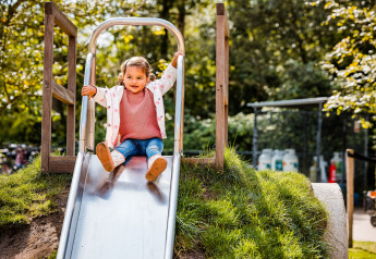 Un niño pequeño juega en un tobogán en el parque infantil de Zweedse Huisjes en Beloofde Land, Países Bajos.