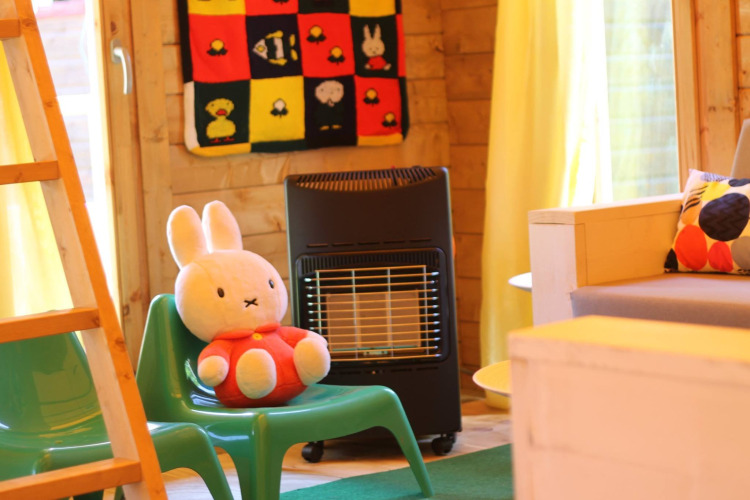 Vista interna di Konijntje huisje a Beloofde Land, Paesi Bassi, con sedie verdi e peluche coniglio.