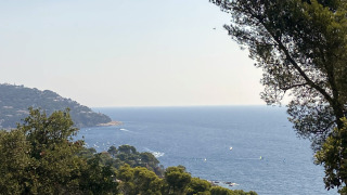 View of the Mediterranean Sea, lush greenery, and hills at Camping Begur in Catalonia, Spain.