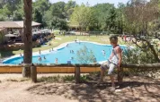 Boy looking over the swimming pool at Camping Begur holiday park in Catalonia, Spain, on a sunny day.