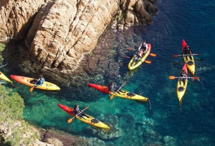 Des kayakistes pagayant dans des eaux claires près des rochers à Palafrugell, Catalogne, Espagne, vue aérienne.