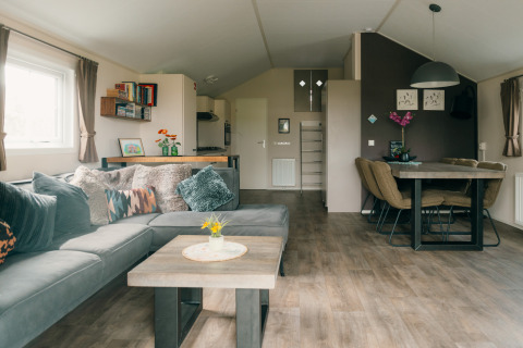 Sala moderna en Veluwe lounge + sauna con comedor en Holiday park De Boshoek, Países Bajos.