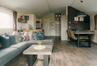 Sala moderna en Veluwe lounge + sauna con comedor en Holiday park De Boshoek, Países Bajos.