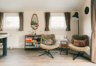 Acogedora sala de estar en Veluwe lounge + sauna con sillones, juegos de mesa y luz natural.