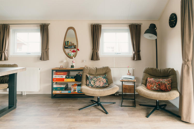 Acogedora sala de estar en Veluwe lounge + sauna con sillones, juegos de mesa y luz natural.