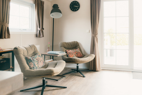 Acogedor salón en Veluwe lounge + sauna, Holiday park De Boshoek, Países Bajos, con dos sillones cómodos.