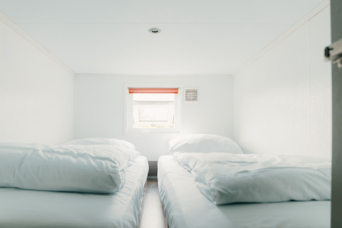 To enkle senge med hvide dyner i et lyst værelse på Veluwe lounge + sauna, De Boshoek, Holland.