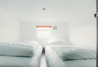 To enkle senge med hvide dyner i et lyst værelse på Veluwe lounge + sauna, De Boshoek, Holland.