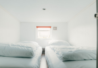 Bright room with two single beds and white bedding at Veluwe lounge + sauna, De Boshoek, Netherlands.