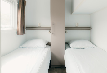 Zwei Einzelbetten im modernen Zimmer der Veluwe Lounge + Sauna im Ferienpark De Boshoek, Niederlande.