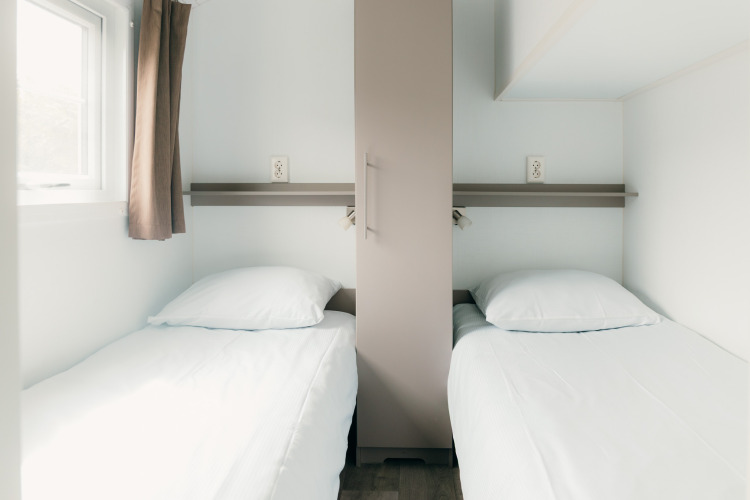 Dos camas individuales en habitación minimalista en Veluwe lounge + sauna, Holiday park De Boshoek, Países Bajos.