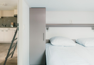 Modernes Lodge-Schlafzimmer und Küche im Veluwe lounge + sauna, Holiday park De Boshoek, Niederlande.