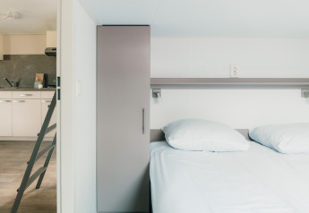 Modernes Lodge-Schlafzimmer und Küche im Veluwe lounge + sauna, Holiday park De Boshoek, Niederlande.