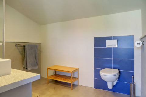 Badkamer in een glampingtent bij Domaine La Barbe in Frankrijk, met moderne inrichting en blauwe wandtegels.