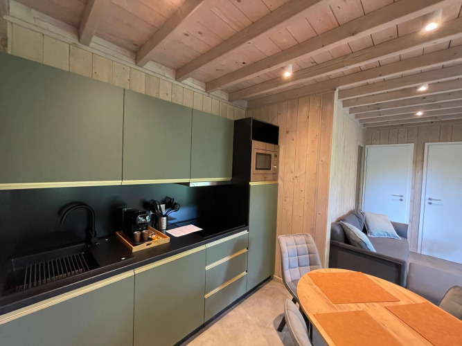 Modernes Küchen- und Wohnzimmerinterieur in Holz im Ecolodge XXL TERRAS, Hameau de l'Ourthe, Belgien.