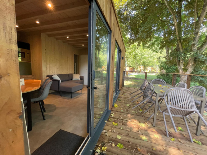 Ecolodge XXL TERRAS im Hameau de l'Ourthe, Belgien, mit moderner Einrichtung, Holzterrasse und Gartenmöbeln.