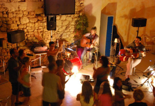Abend mit Livemusik und tanzenden Gästen im Flower Camping La Sagne Ferienpark in Nouvelle-Aquitaine, Frankreich.